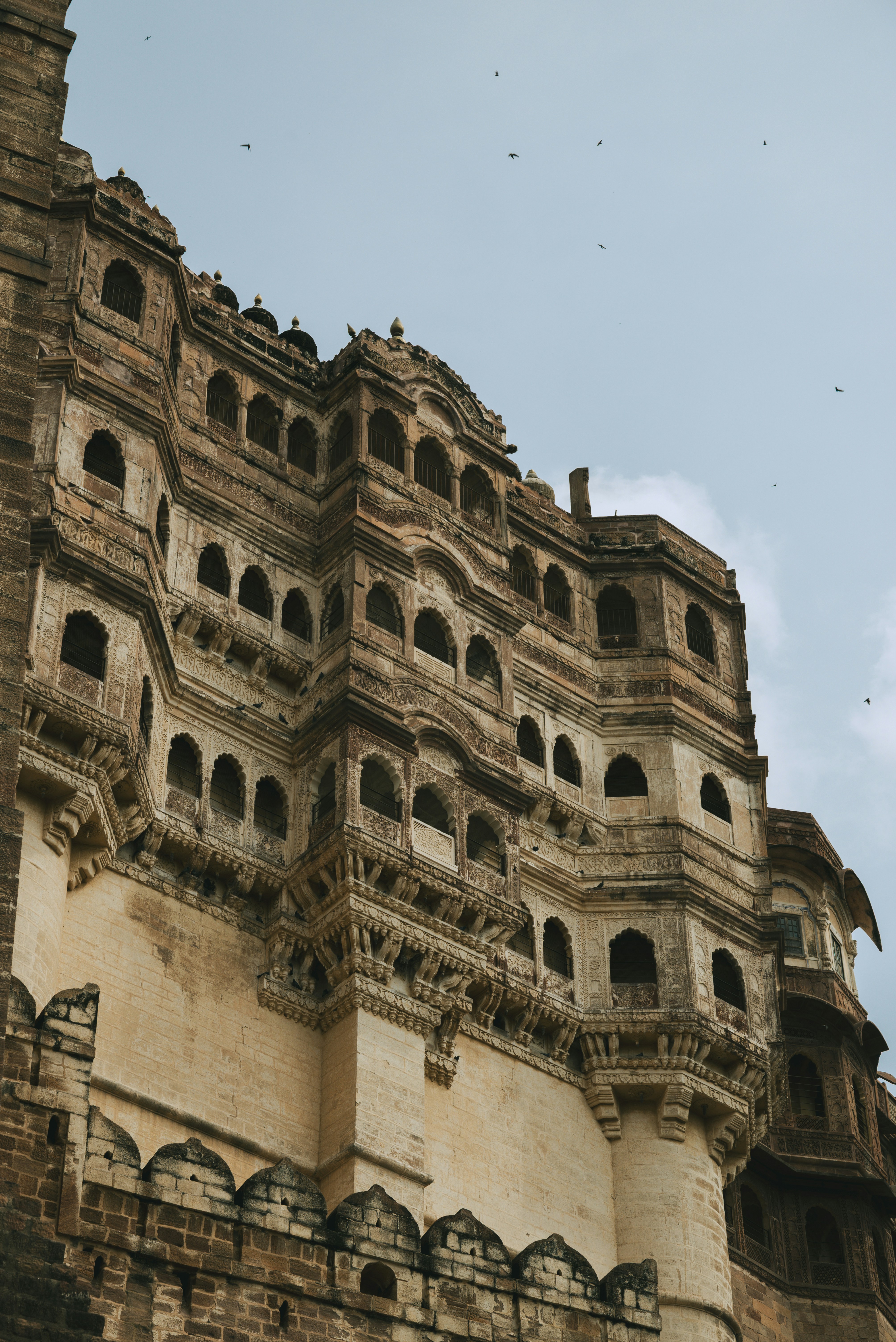 Intricate stone architecture of mehrangarh fort against sky